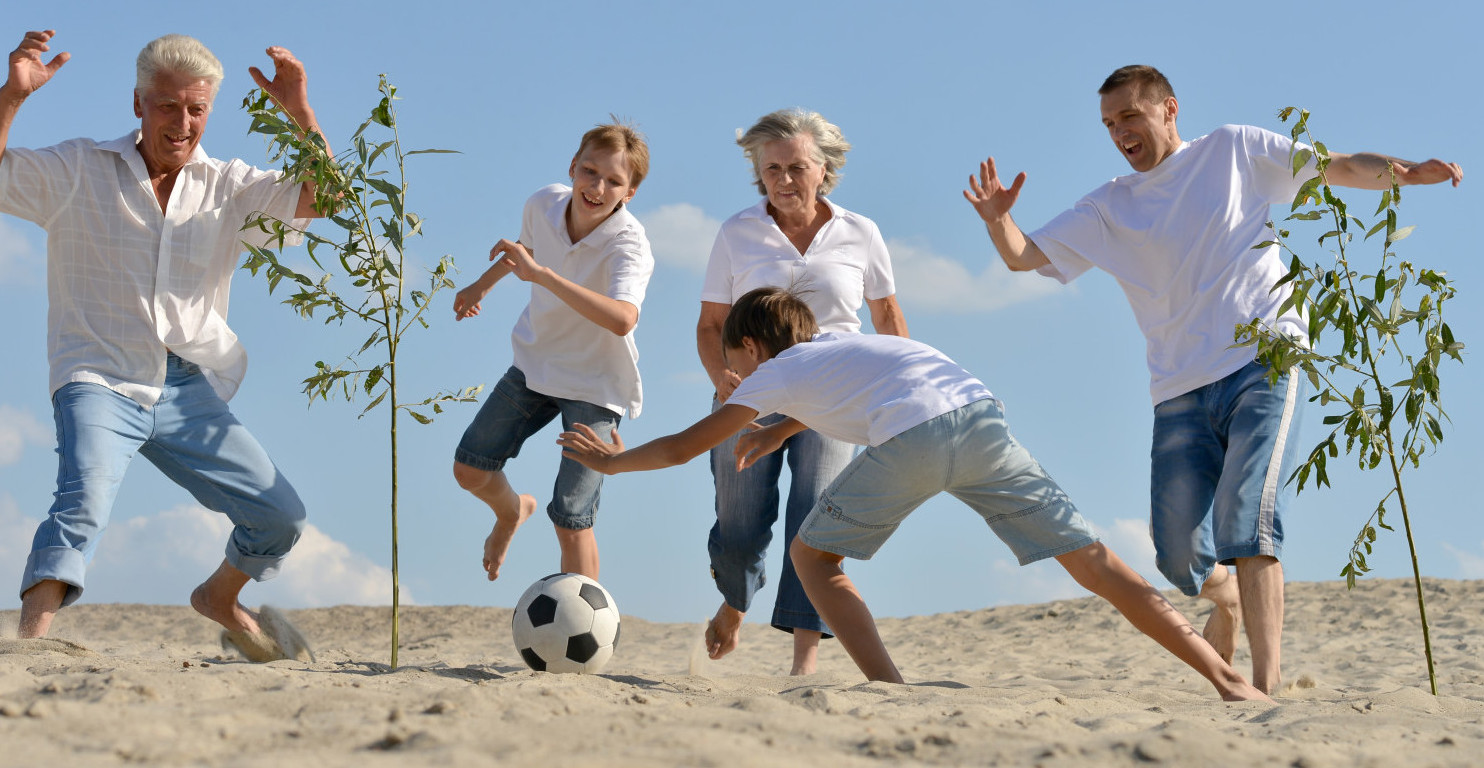 Family soccer game on beach